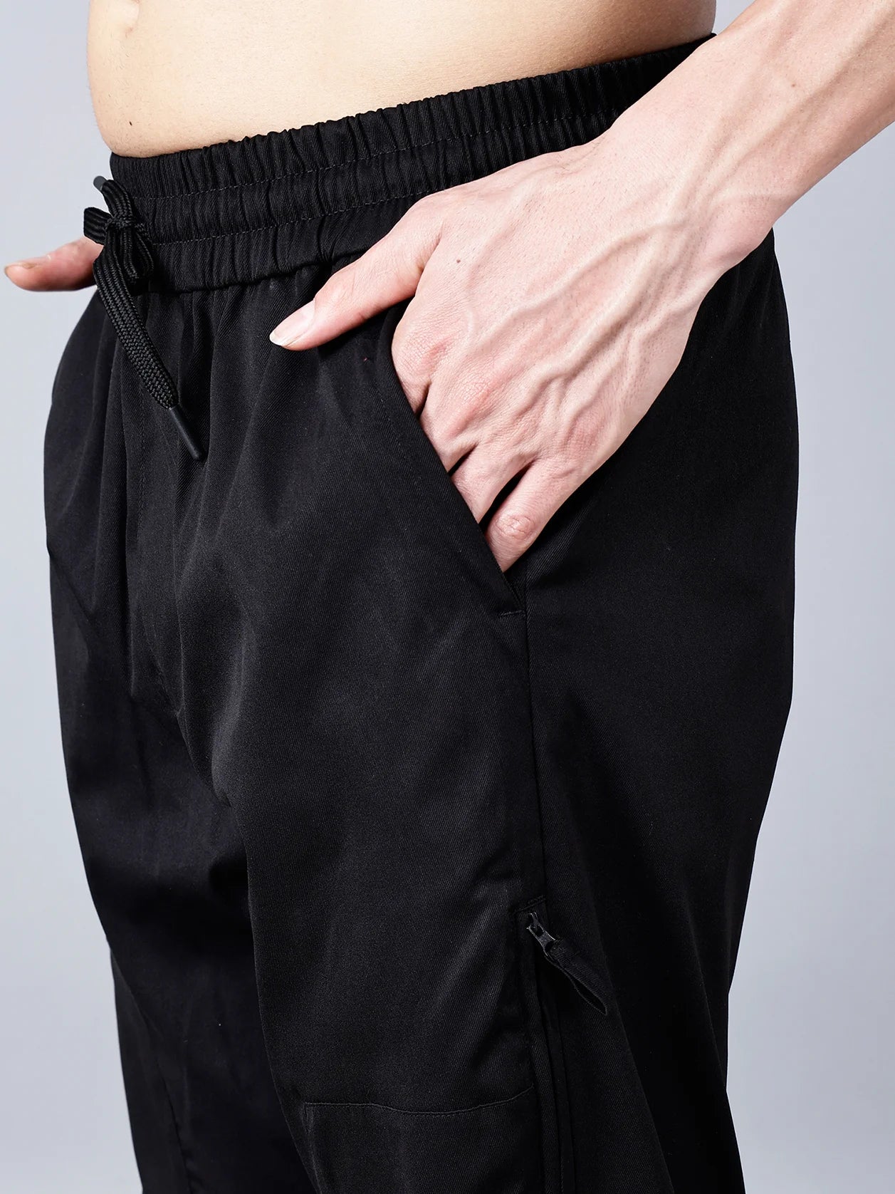 Discover Black Fort Collins Tapered Fit Cargo Track Pants for Men with Zippered Pocket, made from stretchable cotton blend fabric that is both breathable and stylish. These versatile joggers are perfect for any occasion, from the gym to traveling and casual wear. Experience all-day comfort and functionality with these exceptional men's trackpants. Order now online from anywhere in India.