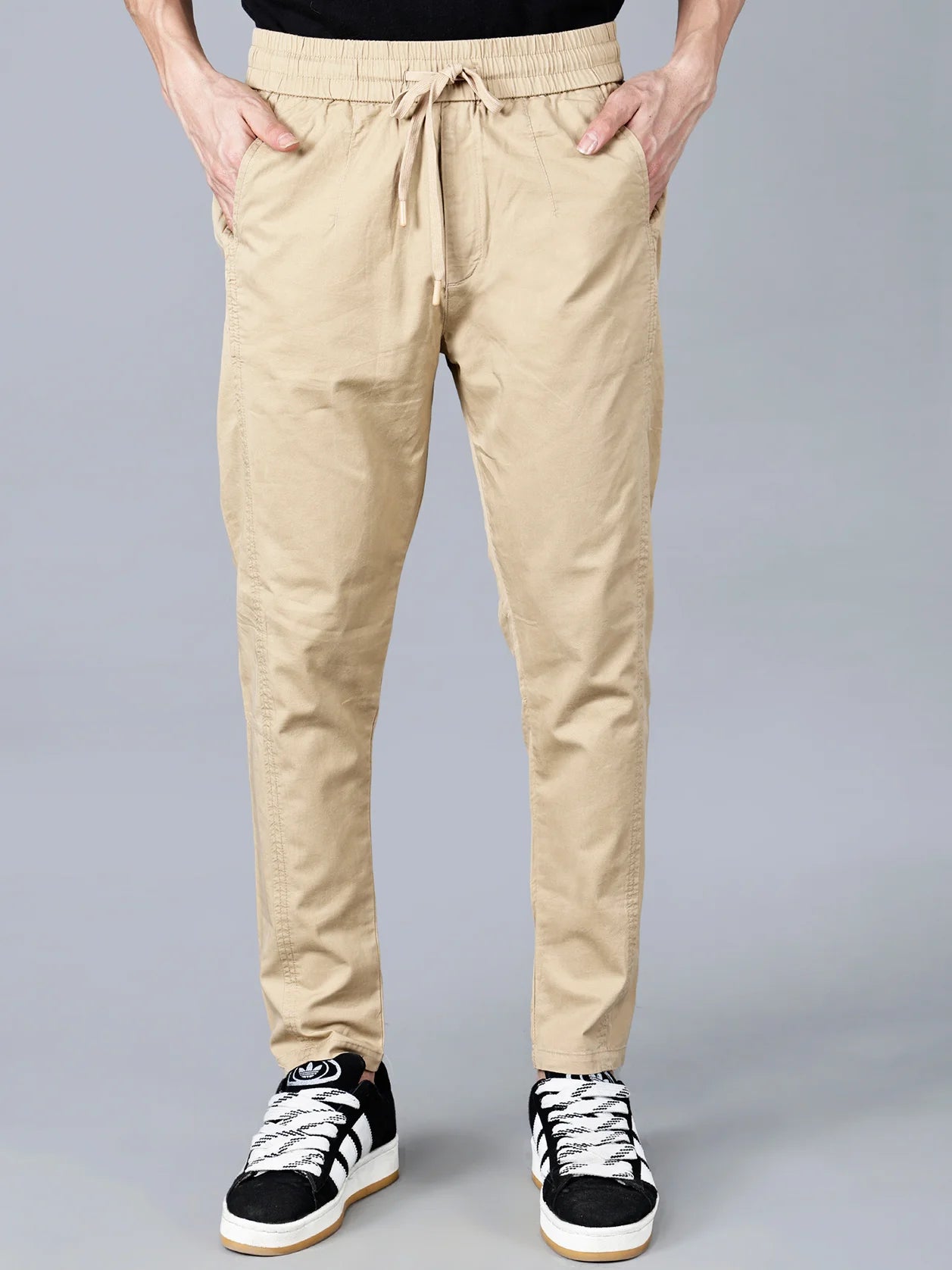Discover Fort Collins men's beige cotton track pant with elastic waist and drawstring – stylish and breathable casual wear with multi-pocket design and clean taper fit. Shop online from anywhere in India.