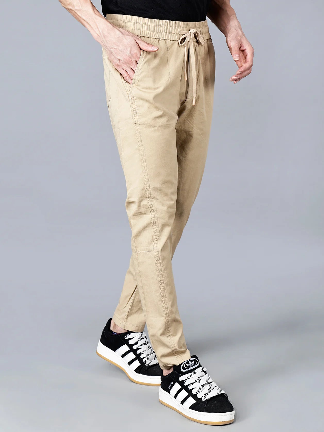 Explore the Men's Beige Cotton Track Pant with Elastic Waistband and Drawstring Closure from Fort Collins. This versatile, comfortable and stylish casual wear features a multi-pocket design and a clean taper fit. Available for online purchase in India.