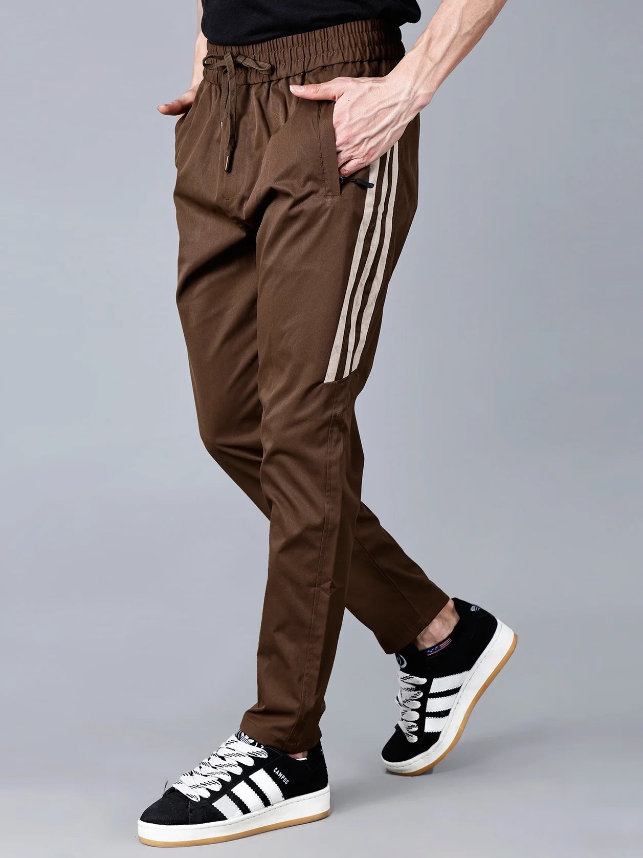 Shop Fort Collins men's brown track pant with beige side stripes, featuring a slim fit, zip pockets, and a comfortable drawstring waist – perfect for workouts or casual wear. Buy now online from anywhere in India.