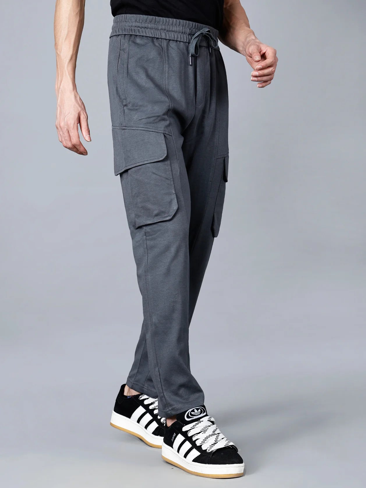 Expertly crafted for ultimate comfort and versatile style, these Men's Charcoal Grey Cargo Track Pants feature durable cotton-polyester fabric, an elastic waistband, and cargo flap pockets. Perfect for any occasion, shop now online from anywhere in India.