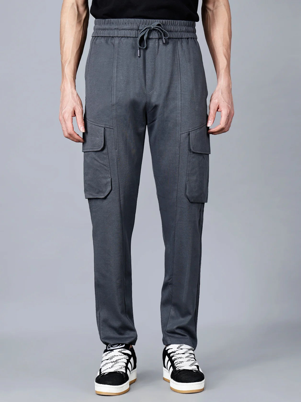 Introducing our Men's Charcoal Grey Cargo Track Pant, designed with functional cargo flap pockets, an elastic waistband, and a sturdy cotton-polyester fabric for ultimate comfort and stylish streetwear. Now available for online purchase from anywhere in India.