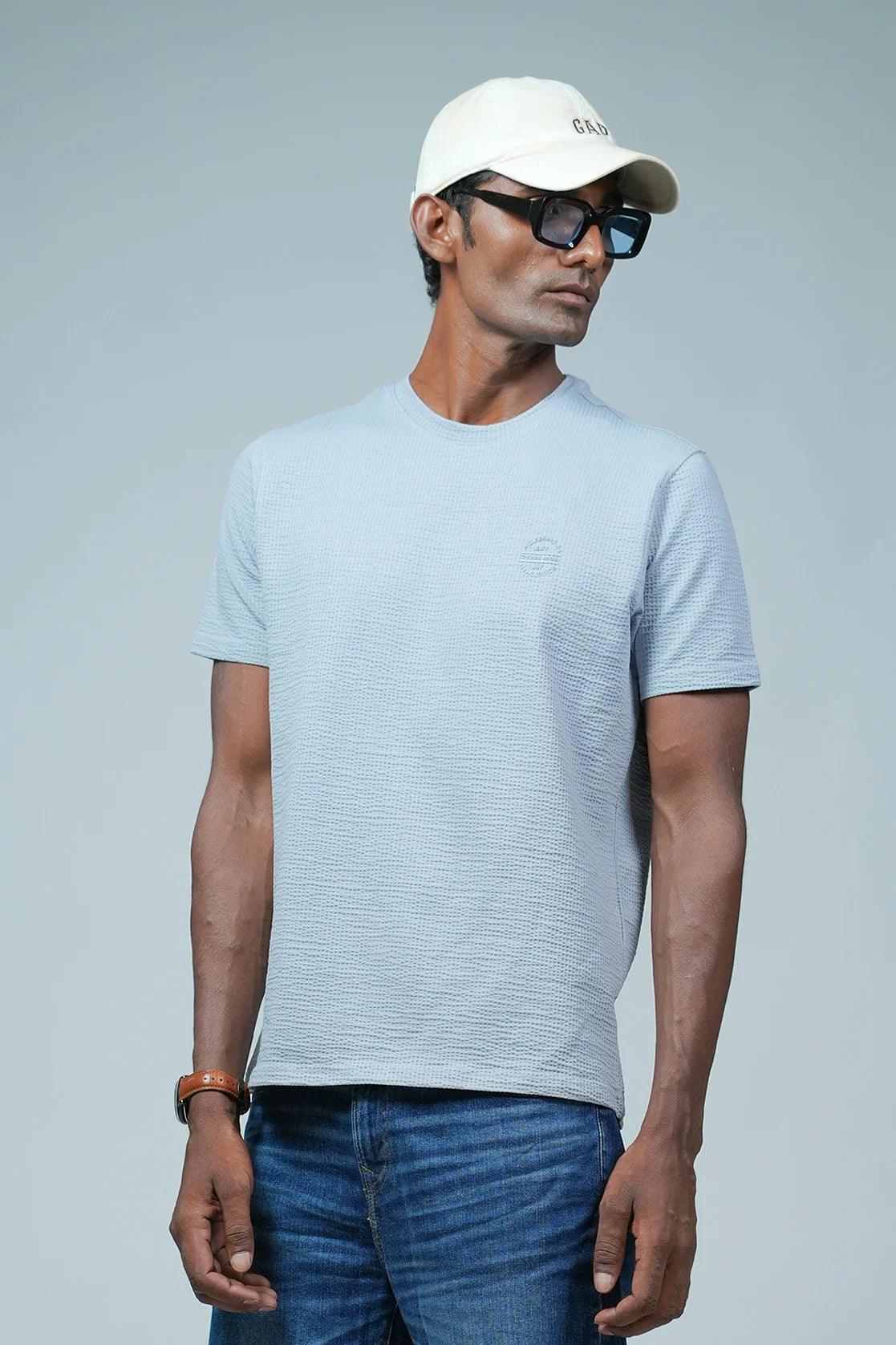 Elevate your style with the Men's Light Blue Structured Cotton-Lycra T-Shirt, featuring a chest logo from Fort Collins. Available online in India for a modern and fashionable addition to your wardrobe.