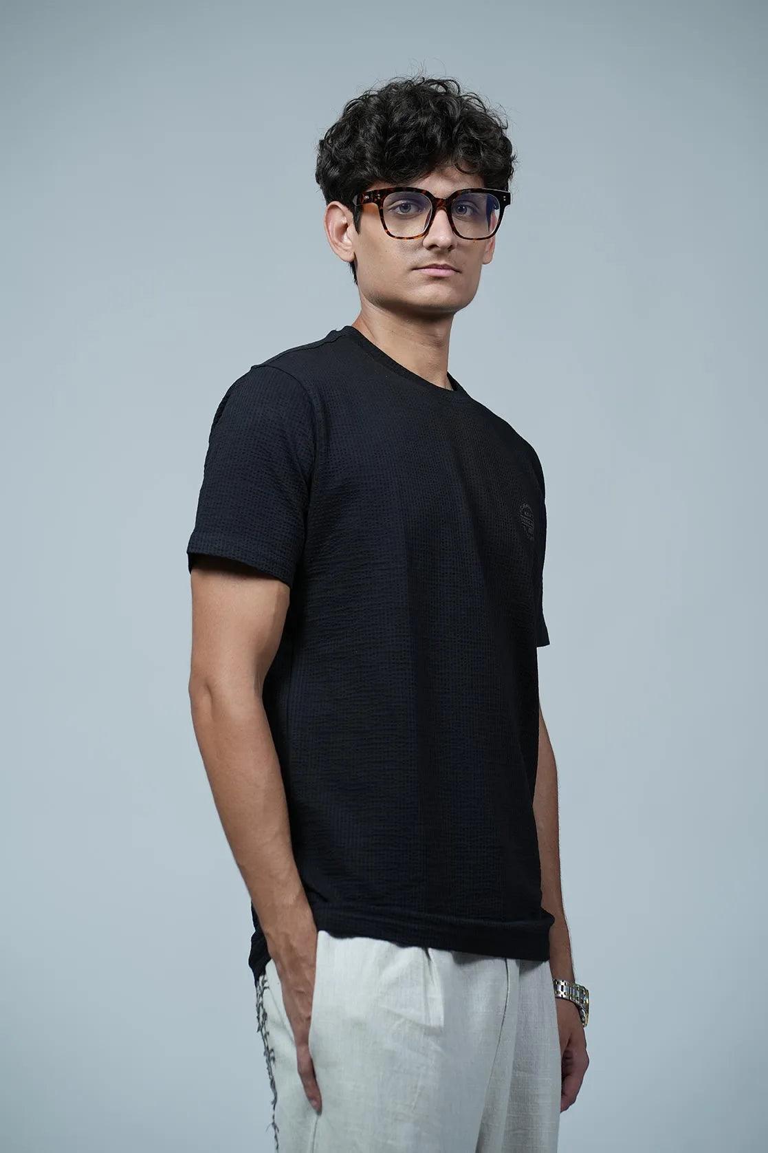 The Men's Structured Fabric Solid Black Round Neck T-Shirt with Chest Logo by Fort Collins provides a sleek and professional look. This shirt features a chest logo design and is made with a structured fabric for added durability and comfort.