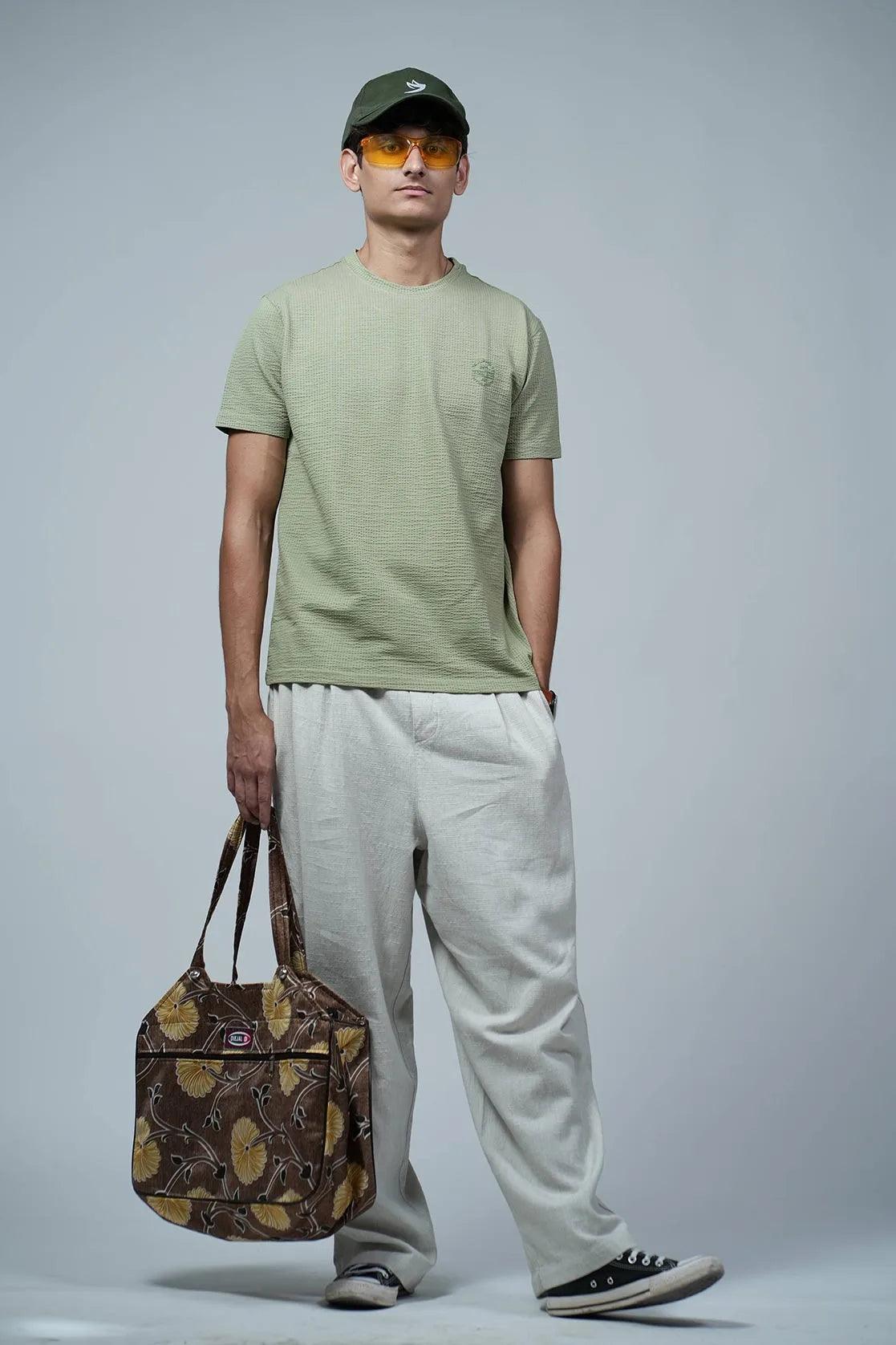 The Men's Structured Fabric Solid Green Round Neck T-Shirt from Fort Collins features a chest logo, making it a stylish and versatile addition to your wardrobe.
