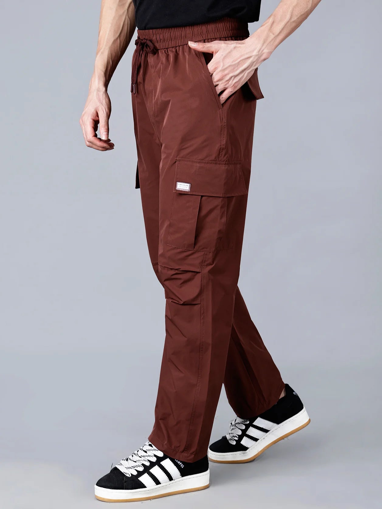 Learn more about the Fort Collins cargo track pants for men in Wine Shade. These pants have a relaxed fit, utility pockets with flap closures, and are made with durable ripstop fabric, making them perfect for the gym, travel, or casual streetwear. Available for purchase online in India, with shipping options available nationwide.