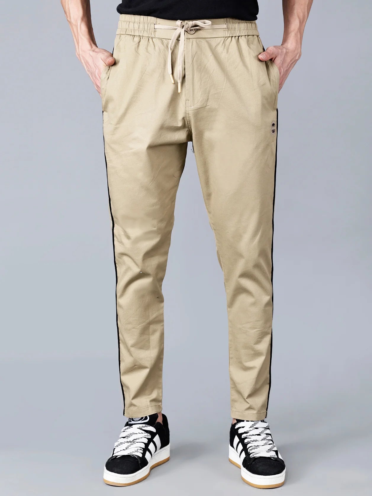 Elevate your wardrobe with our sleek and comfortable khaki Slim Fit Activewear Track Pants for Men. Featuring a stylish black side stripe, stretch cotton blend fabric, and zipper pockets, these casual joggers offer trendy streetwear appeal and everyday comfort. Shop now online for a fashionable upgrade to your clothing collection, available in India.