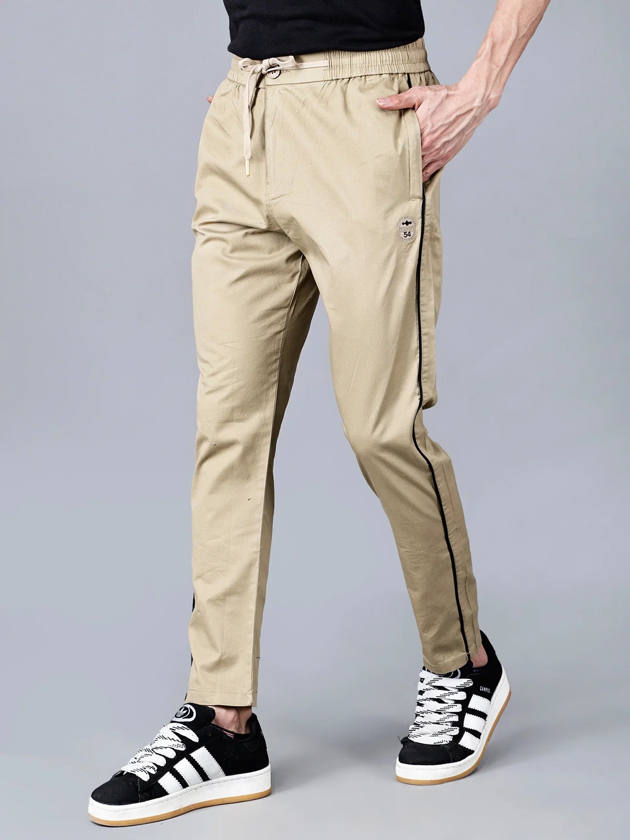 Upgrade your everyday wardrobe with the khaki Slim Fit Activewear Track Pants for Men. These stylish joggers feature a black side stripe, stretch cotton blend fabric, and zipper pockets for convenient storage. Shop now for this must-have addition to your casual and streetwear collection, available for purchase from anywhere in India.