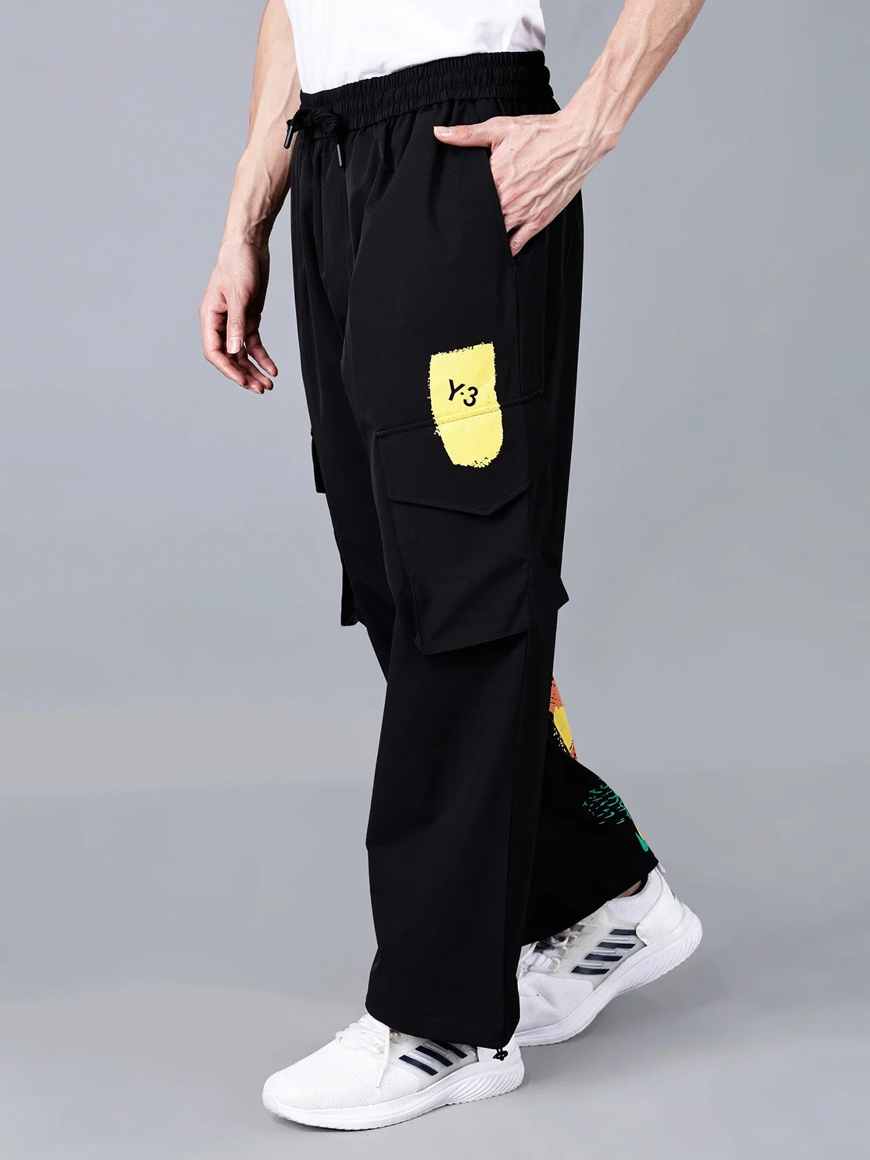 Explore our men's black cargo track pants with a Y-3 yellow patch and vibrant multicolor brushstroke print. These fashionable pants feature a relaxed fit and are perfect for the gym, travel, and streetwear. Shop now on our website and enjoy shipping across India.