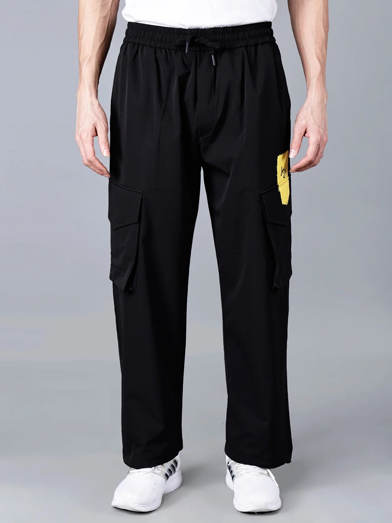 Shop now for Solid Black Cargo Track Pants for Men featuring a Multicolor Brushstroke Print and Y-3 Yellow Patch. These stylish, relaxed fit pants are perfect for the gym, travel, and streetwear fashion. Purchase online in India and enjoy nationwide shipping.