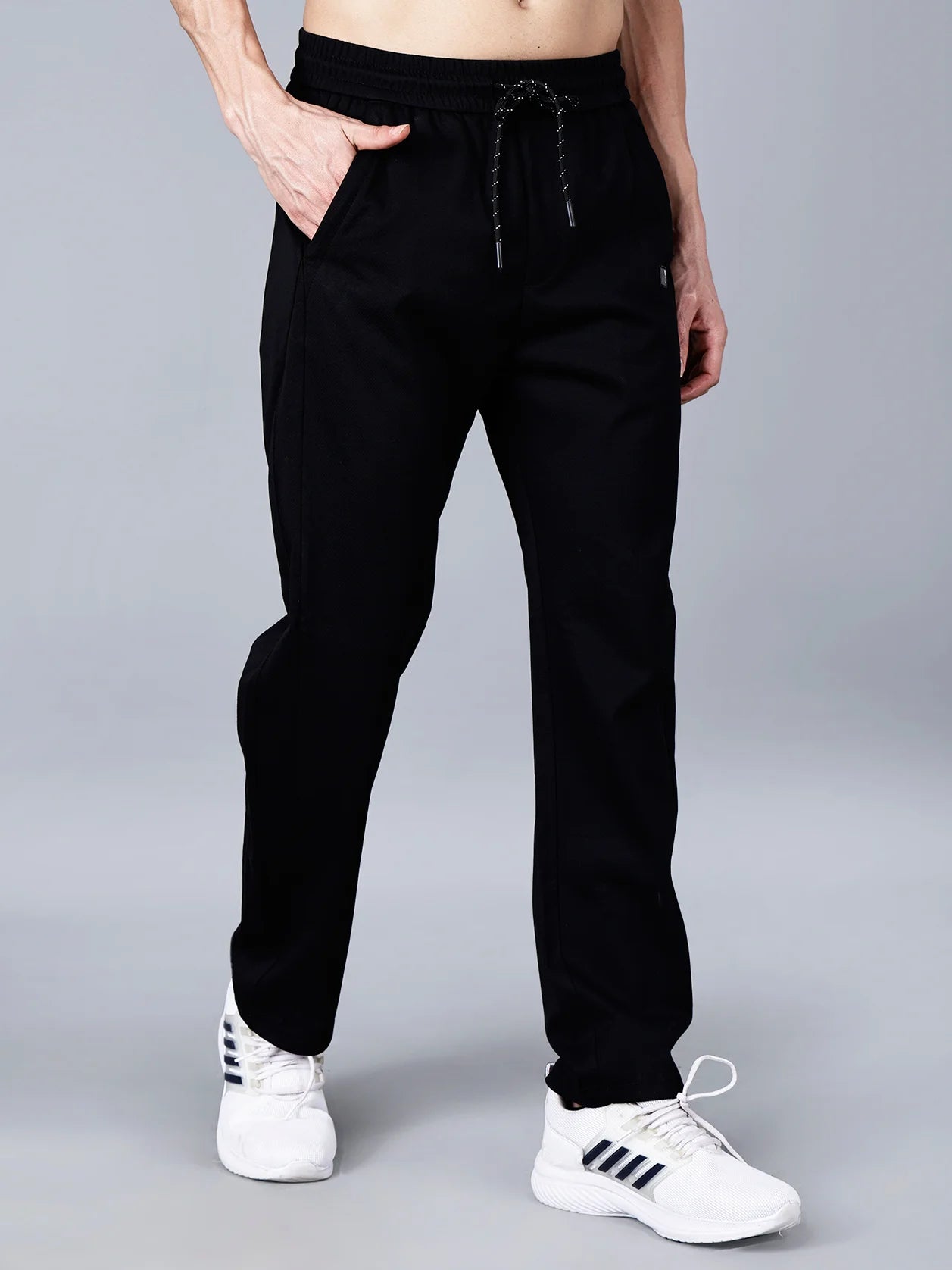Enhance your wardrobe with Fort Collins' black cotton track pants for men. These stylish pants feature a smart taper fit, an elastic waistband with a drawstring for a comfortable fit, and a practical pocket design. Don't miss out on the latest trend in track pants, shop online in India now.