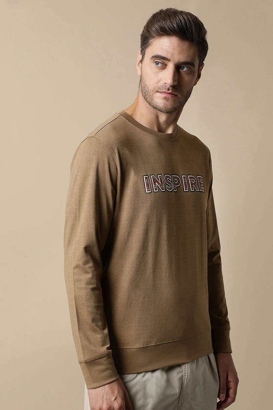 Upgrade your wardrobe with the Fort Collins Men's Camel Color Round Neck Sweatshirt, featuring a stylish chest print. Shop online and elevate your fashion game from anywhere in India.