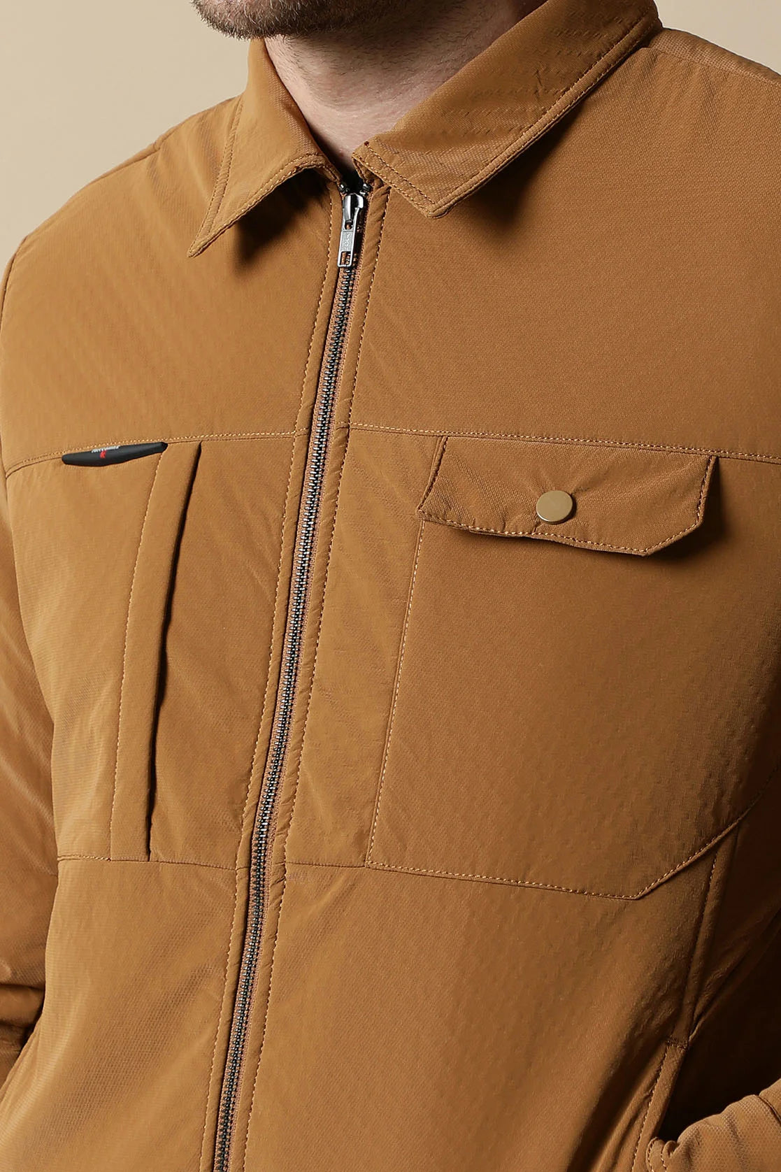 Crafted for men, this Tan PU Coated Jacket features a Classic Front Zip design. For a stylish touch, pair it with our Beige Stretchable T-Shirt showcasing a New York Graphic Print.