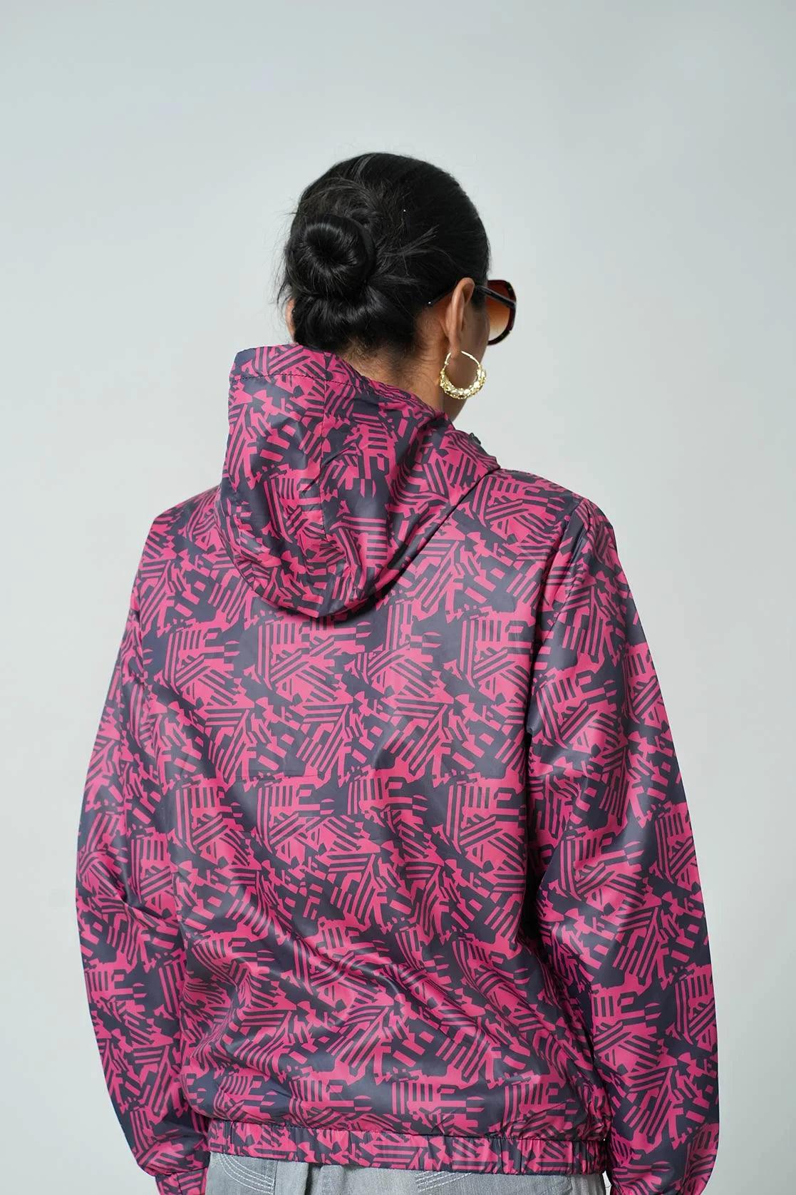 Expertly crafted for women, this windbreaker jacket in red features an abstract print and an adjustable hood. Ships across India.