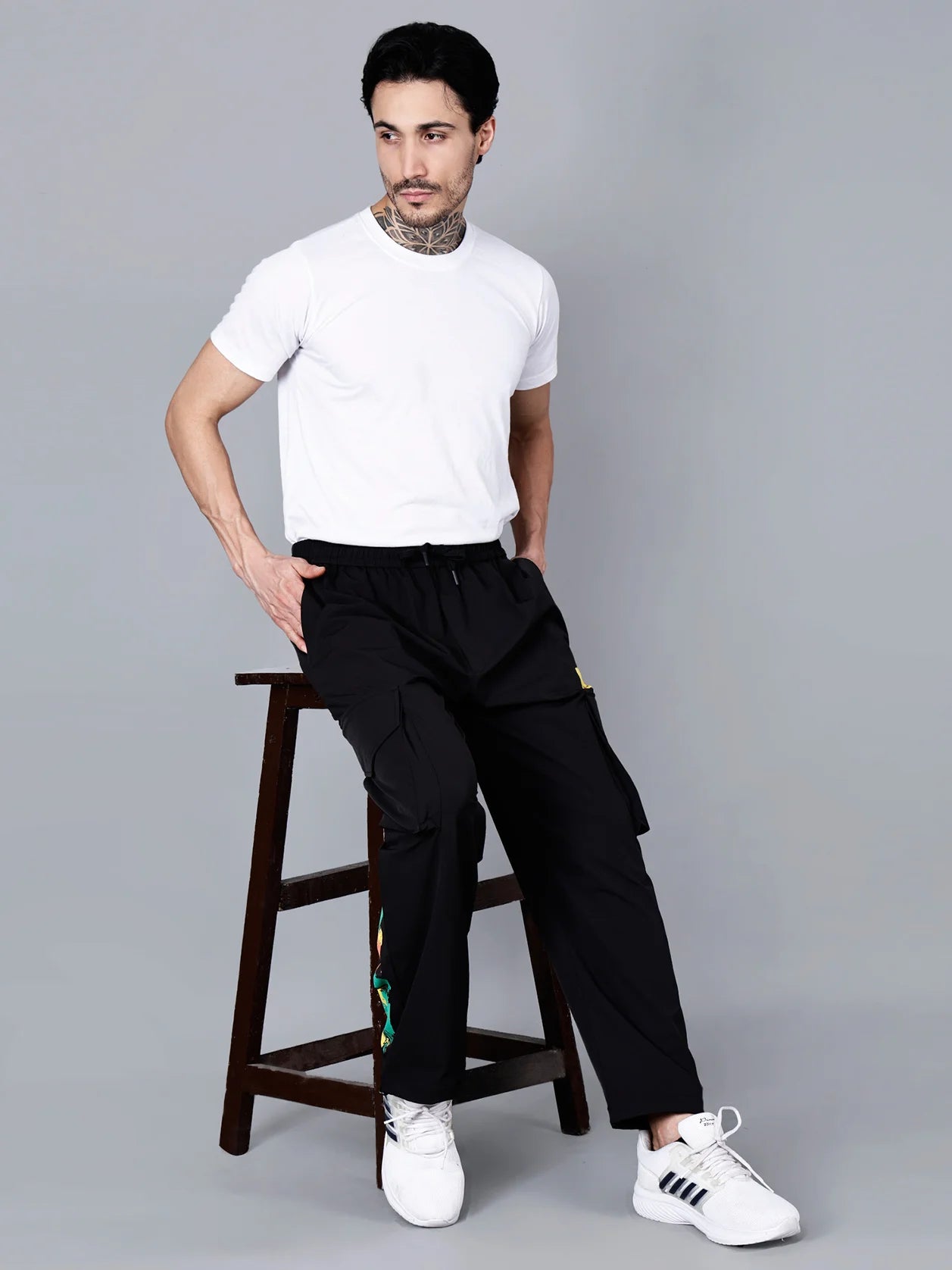 Explore the sleek and functional design of these Solid Black Cargo Track Pants for Men, featuring a bold multicolor brushstroke print and a Y-3 yellow patch. Perfect for the gym, travel, or streetwear fashion, these pants offer a relaxed fit for ultimate comfort. Order now in India and receive fast shipping across the country.