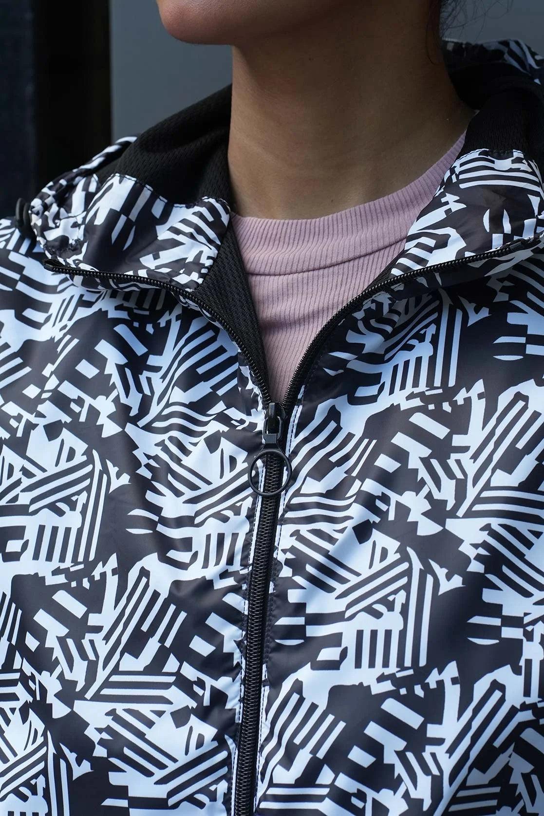 Discover the Fort Collins Women's Abstract Printed Windbreaker Jacket now available for purchase in India, featuring an adjustable hood and stylish white abstract design.